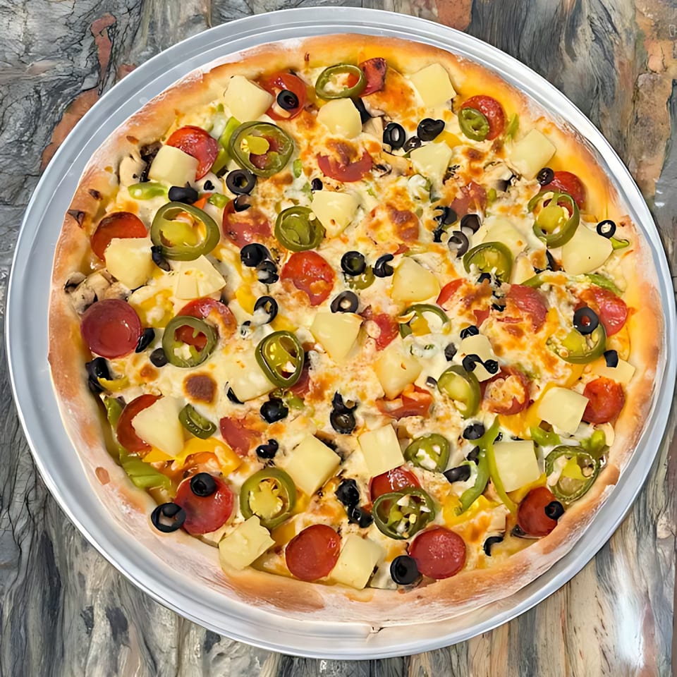 A Boba & Pizza Corner pizza with pepperoni, pineapple, jalapeños, and olives on a metal tray.