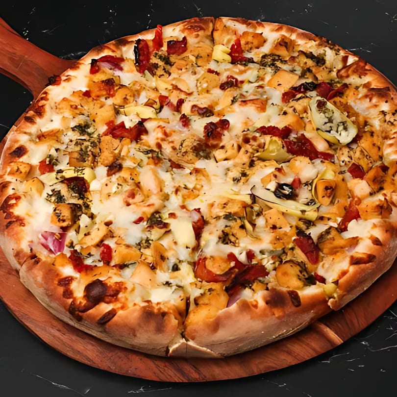 A Boba & Pizza Corner pizza with chicken, red peppers, and artichoke hearts on a wooden peel.