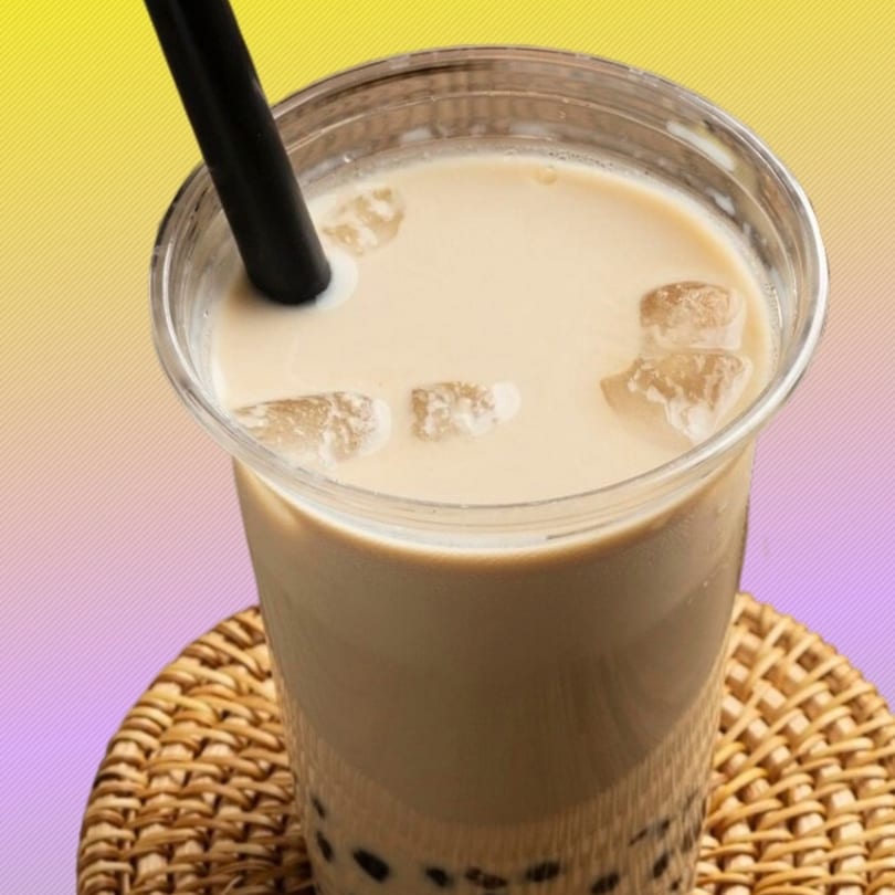 Boba & Pizza Corner's iced boba tea with a black straw on a woven coaster.